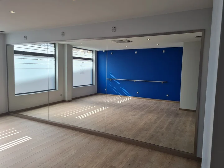 Mur de miroirs pleine hauteur posés sur cornières dans une salle de danse